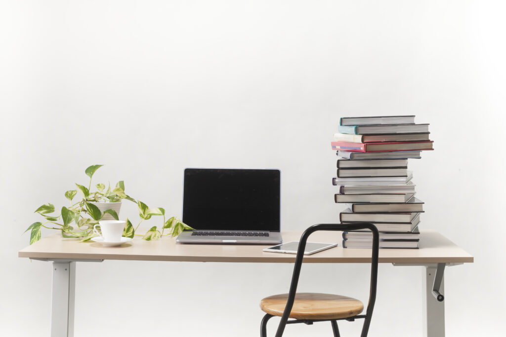 パソコンと本、コーヒー、植物が乗っている机